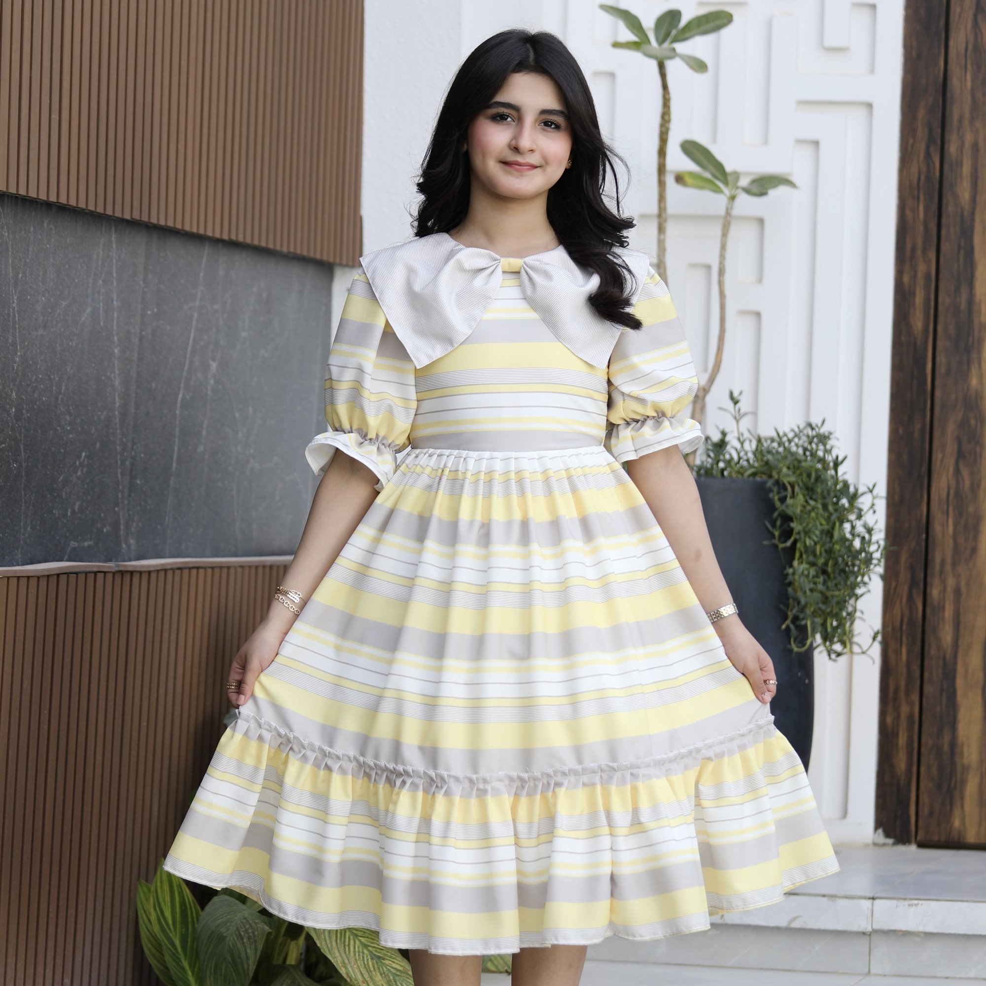 فستان بناتي مخطط أصفر ورمادي بياقة فيونكة منسدلة وكشكشة - 1152